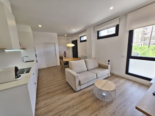 Apartamento moderno en BR SILGAR de Sanxenxo con cocina, sala de estar, sofá beis, suelos de madera y luz natural