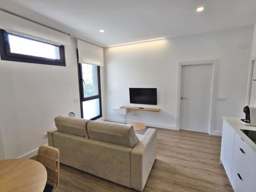 Moderno apartamento Sanxenxo Silgar con sofá beige, TV, cocina y luminoso salón para 4 huéspedes