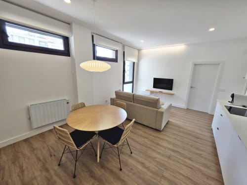 Moderno apartamento diáfano en BR SILGAR, Sanxenxo con mesa de comedor, sofá, TV y zona de cocina