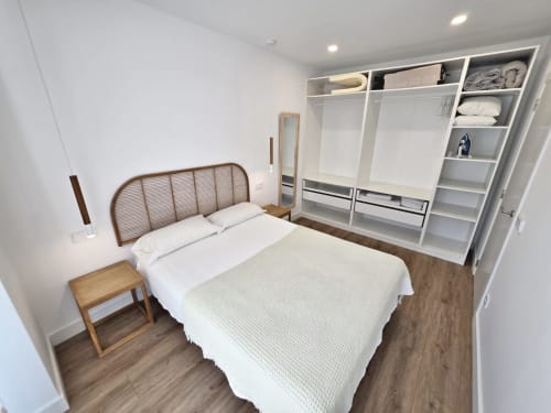Dormitorio del apartamento BR SILGAR en Sanxenxo con cama, cabecero de madera, mesita de noche y armario empotrado