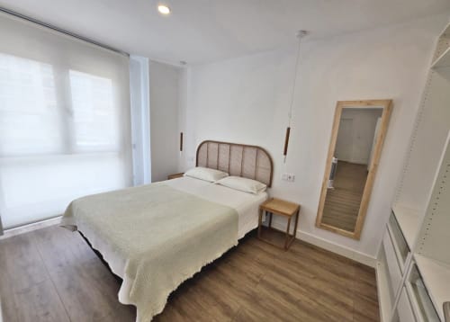 Luminosa habitación en BR SILGAR de Sanxenxo con cama doble, cabecero de madera, espejo y equipamiento moderno