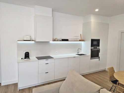 Cocina moderna de diseño blanco en apartamento BR SILGAR, Sanxenxo con electrodomésticos de acero inoxidable y piso de madera
