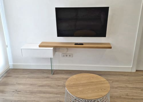 Salón moderno de apartamento en Sanxenxo con televisor montado en pared, estantería de madera, mueble blanco y mesa auxiliar redonda de madera