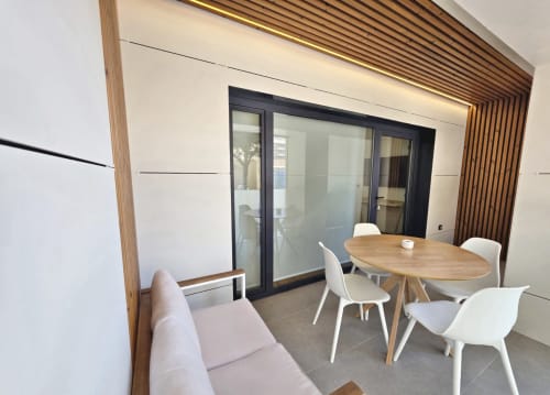 Sala del Club BR Silgar en Sanxenxo con comedor moderno, mesa de madera, sillas blancas y acceso a terraza