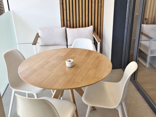 Sala del Club BR Silgar en Sanxenxo con mesa de comedor redonda de madera, sillas blancas y zona de descanso