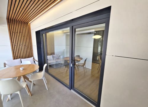 Sala del BR Silgar Club con mesa de comedor de madera, asientos modernos y puertas de cristal que se abren al área de estar en Sanxenxo
