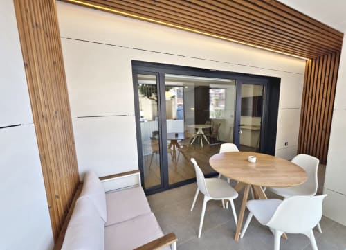 Sala del BR Silgar Club en Sanxenxo con comedor, mesa de madera, sillas blancas y modernas puertas de patio