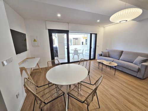 Salón del BR Silgar Club en Sanxenxo con mesa de comedor redonda, zona de descanso y acceso a terraza