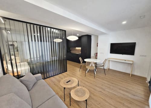 Habitación moderna del BR Silgar Club en Sanxenxo con sala de estar, mesa de comedor, TV de pantalla plana y mobiliario minimalista