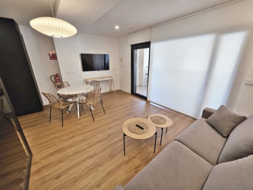 Sala lounge del BR Silgar Club en Sanxenxo con zona de estar, televisión, mesa de comedor y mobiliario moderno