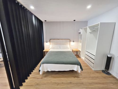 Habitación moderna en BR Silgar Club de Sanxenxo con cama, armario blanco, suelos de madera y cortinas oscuras