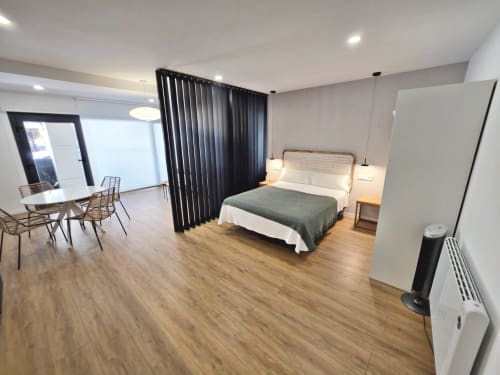 Habitación Club BR Silgar en Sanxenxo con cama, zona de comedor, cortinas negras y comodidades modernas