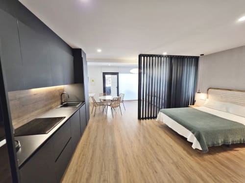 Habitación del Club BR Silgar en Sanxenxo con cocina moderna, cama, zona de comedor y cortinas con vistas al océano