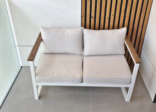 Sofá moderno de dos plazas con estructura blanca y detalles de madera en la sala BR Silgar Club, Sanxenxo