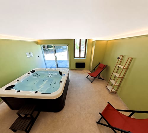 Chambre jacuzzi de luxe avec transats rouges à la maison d'hôtes Maison Agami à Rosières aux salines