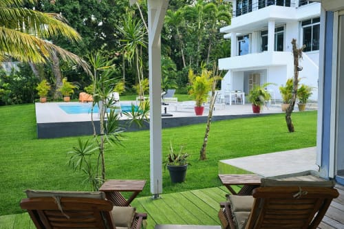 Terrasse du bungalow à l'Habitation Villa Les Cassias à Petit-Bourg avec vue sur la piscine, chaises longues et pelouse entretenue