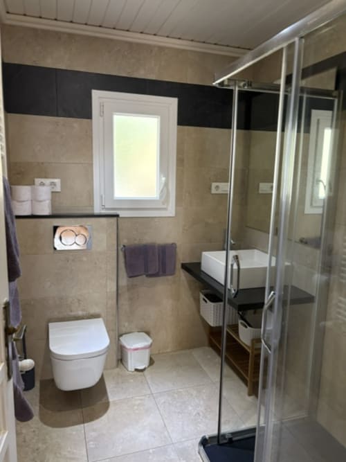 Baño moderno en Suite 3 de Casa Marina Suites con ducha grande, inodoro y tocador con lavamanos
