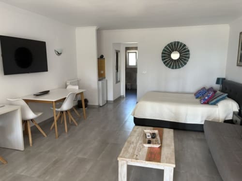Casa Marina Suites Suite 4: Moderno estudio con cama, escritorio, TV, kitchenette y vista a la piscina