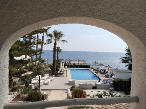 Balcón con vista al mar de Casa Marina Suites con piscina Mediterránea, palmeras y playa