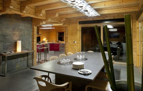 Salle à manger de villa moderne en bois aux Chalets d'Aline avec vue montagne, table contemporaine et cuisine