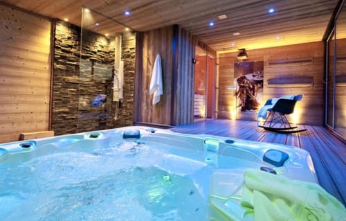 Suite spa luxe aux Chalets d'Aline avec bain à remous, douche en pierre et vue montagne dans les Alpes