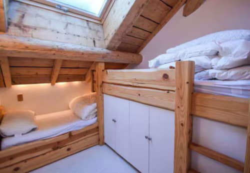 Chambre cosy avec lits superposés en bois et literie blanche aux Chalets d'Aline, villa de montagne à La Plagne Tarentaise