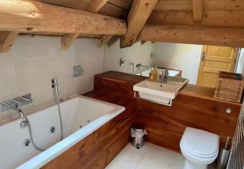 Salle de bain spacieuse avec poutres en bois, baignoire, lavabo séparé, toilettes et douche à la villa Les Chalets d'Aline à La Plagne