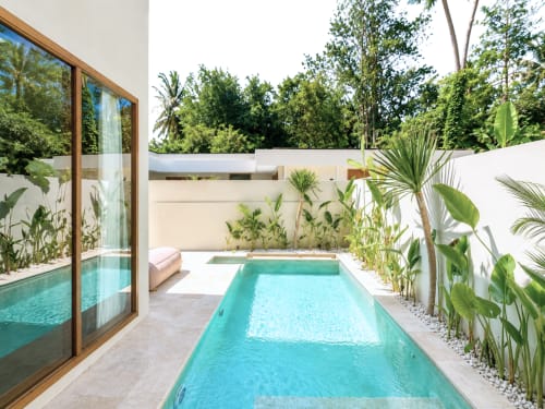 Piscina turquesa en el patio de villa privada en Oasis Dune Villas, Lombok, rodeada de plantas tropicales y paredes blancas
