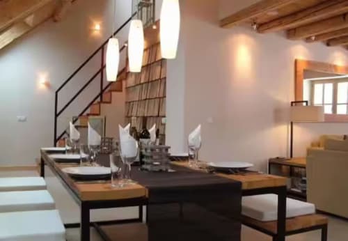 Salle à manger contemporaine aux Chalets d'Aline à La Plagne avec table en bois, luminaires suspendus et escalier.