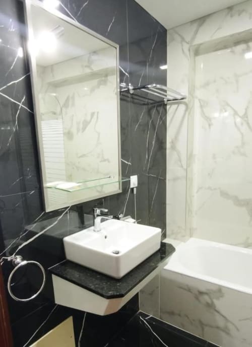 Modern bathroom at Hotel Slow Stay in Esposende featuring black marble tiles, white vessel sink, illuminated mirror, and
