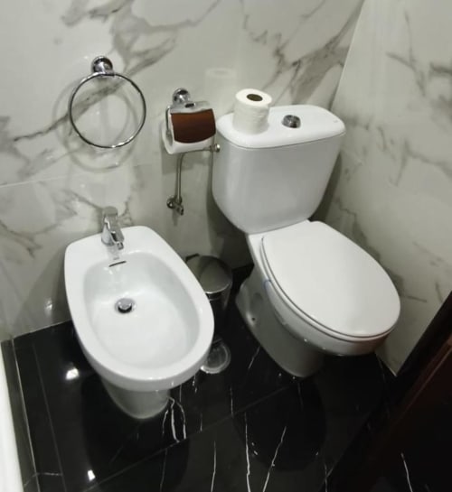 Modern bathroom fixtures in Hotel Slow Stay Deluxe Double Room, Esposende with bidet, toilet, and marble walls