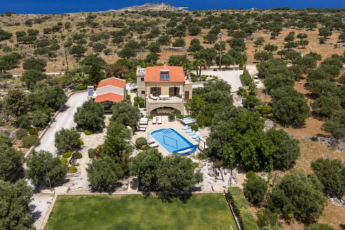 Villa Freedom BnB aerial view with pool, terracotta roof, surrounded by olive trees in Kokkino Chorio, Crete