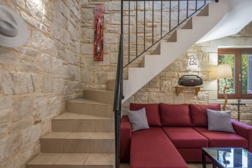 Modern living room with red sofa and stone staircase at Villa Freedom, Kokkino Chorio, Crete