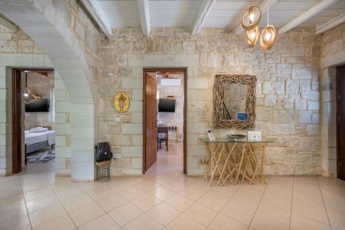 Villa Freedom B&B spacious reception area with stone walls, wooden furnishings, and pendant lighting in Crete