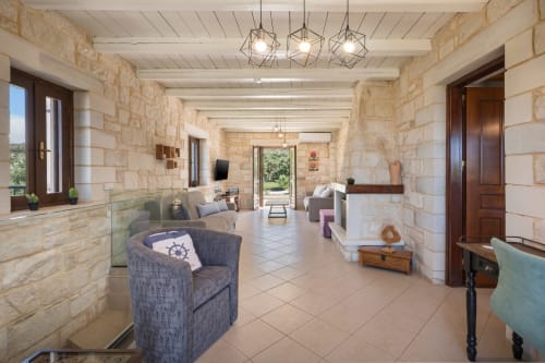 Villa Freedom lobby in Kokkino Chorio, Crete with stone walls, modern furnishings, and terrace access