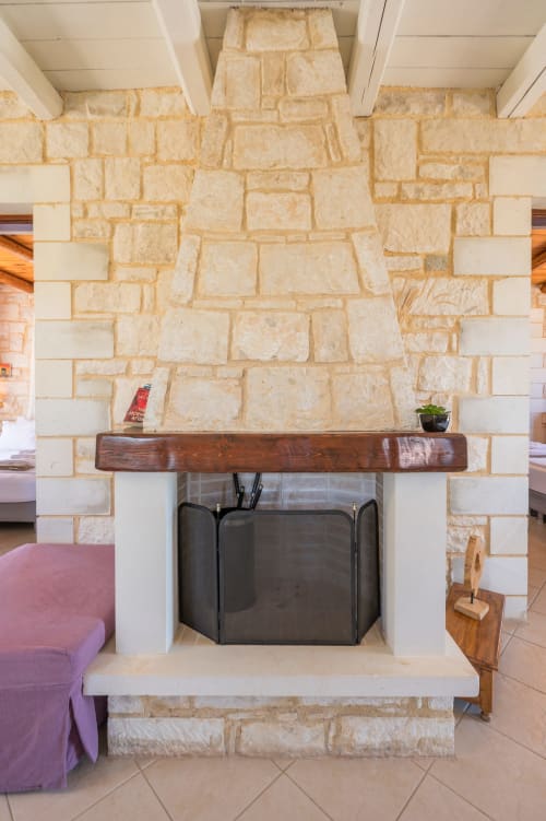 Stone fireplace with wooden mantel at Villa Freedom, a Crete bed and breakfast in Kokkino Chorio