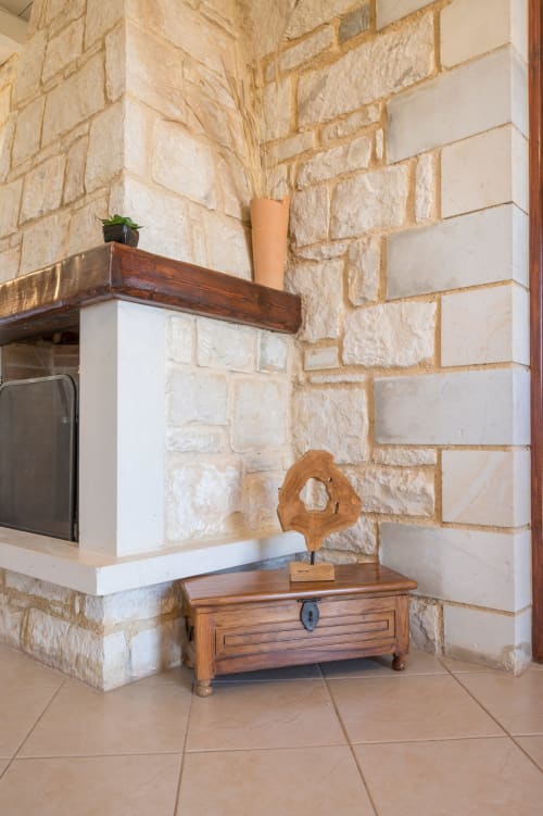Stone fireplace with wooden beam at Villa Freedom, a Crete bed and breakfast in Kokkino Chorio featuring rustic décor and