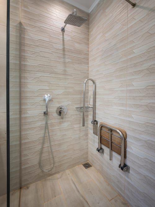 Accessible shower at Villa Freedom with rainfall showerhead, grab bars, and modern tilework in Kokkino Chorio, Crete