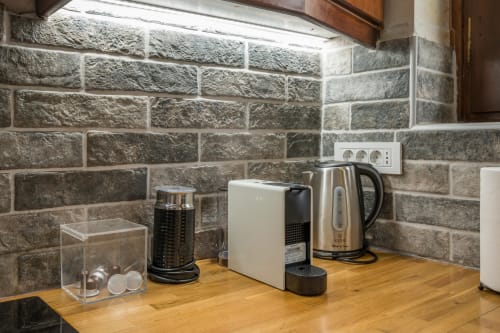 Kitchen counter at Villa Freedom in Crete with stone backsplash, coffee maker, kettle, and capsule machine
