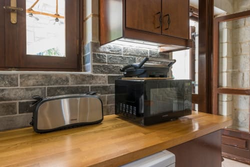 Kitchen counter at Villa Freedom B&B in Crete with toaster, microwave, and stone backsplash