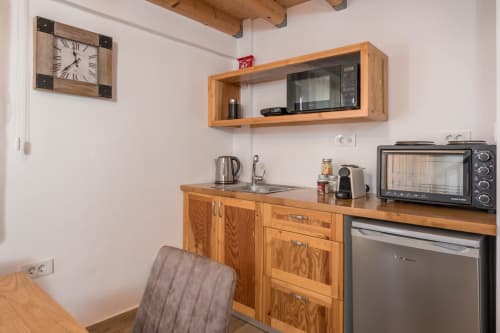 Compact kitchenette at Villa Freedom in Crete with wooden cabinetry, microwave, and modern appliances
