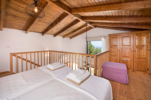 Rustic wooden bedroom at Villa Freedom in Kokkino Chorio, Crete with exposed beams and sea views