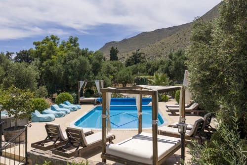 Villa Freedom's resort pool with loungers, pergola seating, and mountain views in Kokkino Chorio, Crete
