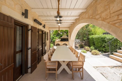 Villa Freedom covered dining patio with long table and wooden chairs overlooking garden in Kokkino Chorio, Crete
