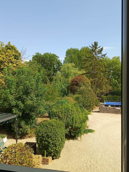 Vue luxuriante du Jardin de la Reyssouze avec arbres matures et allées sablonneuses à Gorrevod