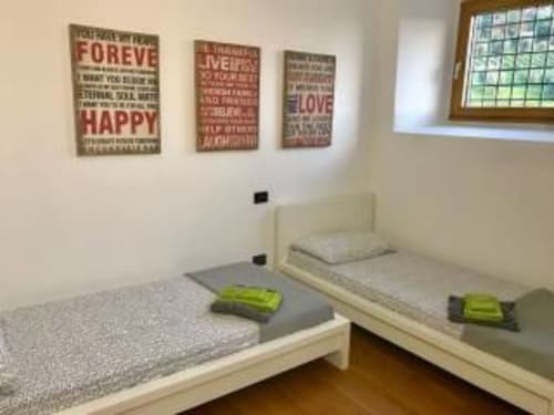 Camera doppia nella Rosa room dell'Appartamento Franciacorta B&B, Cazzago San Martino, con decorazione murale motivazionale e vista sul giardino