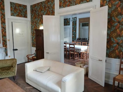 Salon avec canapé blanc au château de Mons Boubert, papier peint à fleurs et salle à manger visible