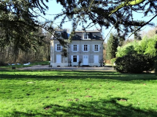 Le château de Mons Boubert, villa avec pelouse soignée et arbres environnants à Mons-Boubert, France