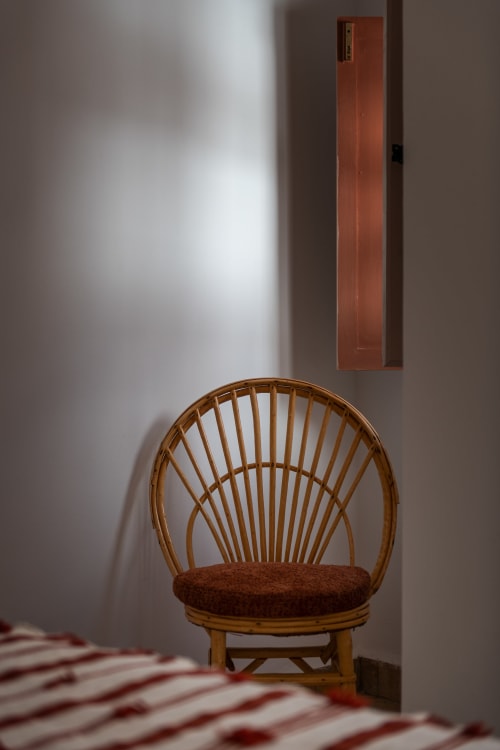 Chaise en bois à dossier ajouré avec coussin marron dans une chambre de l'hôtel Dabachi, Marrakech