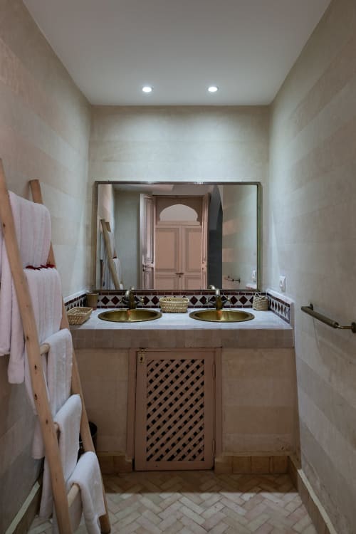 Salle de bains luxueuse de l'hôtel Dabachi à Marrakech avec vasques dorées, plan de marbre et carrelage décoratif